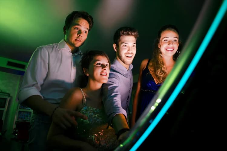 A group of people addicted to gambling staring at a slot machine in a casino.