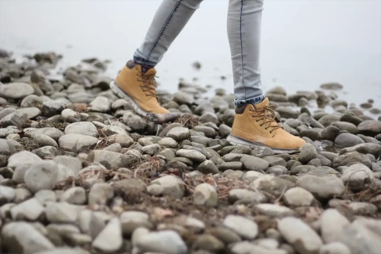 A person walking on the rocks taking steps to improve their life.
